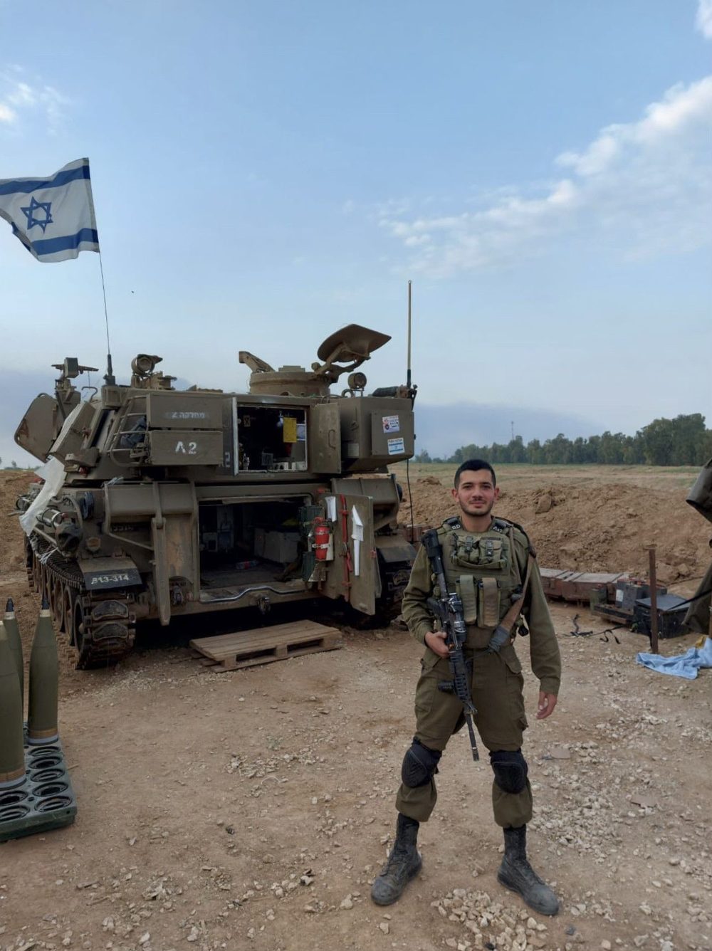 Eitan in uniform in front of an artillery vehicle